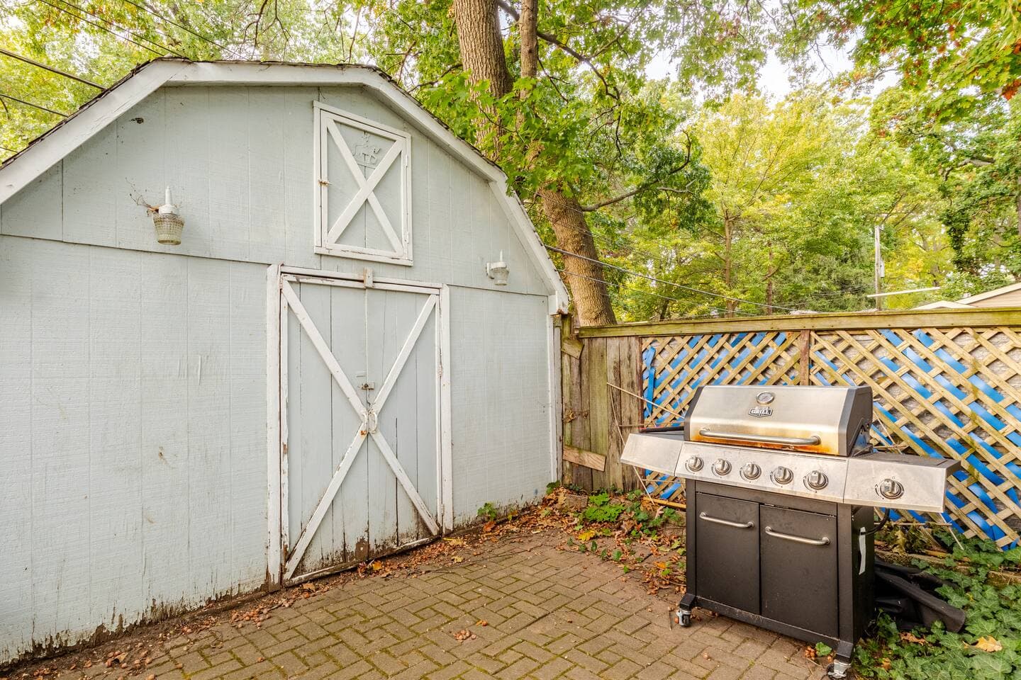 Gas grill and garden shed on the paver patio