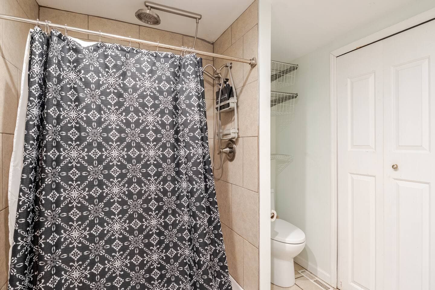 Full bathroom with a patterned shower curtain