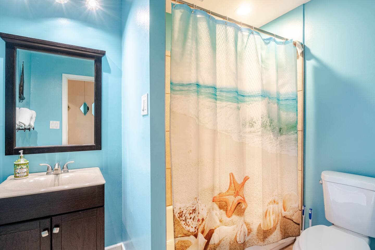 Beach-themed full bathroom with walk-in shower