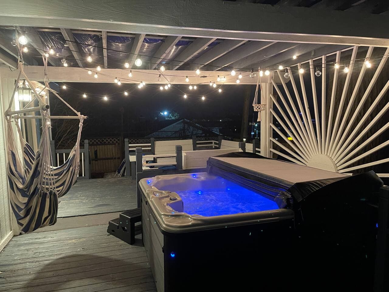 Hot tub glowing under string lights at night