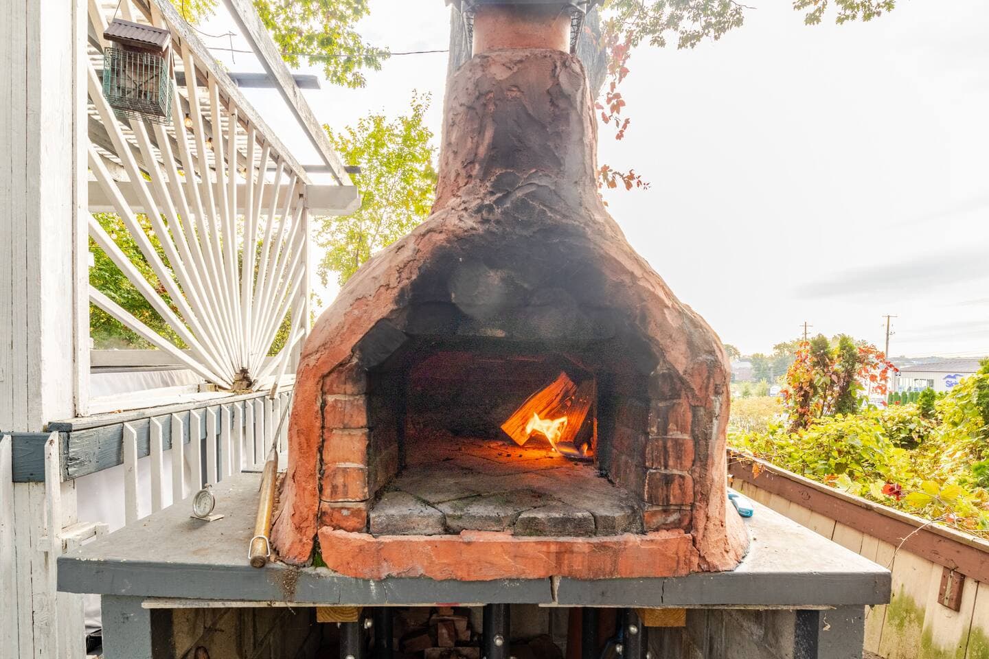 Wood-fired brick pizza oven with a daytime fire