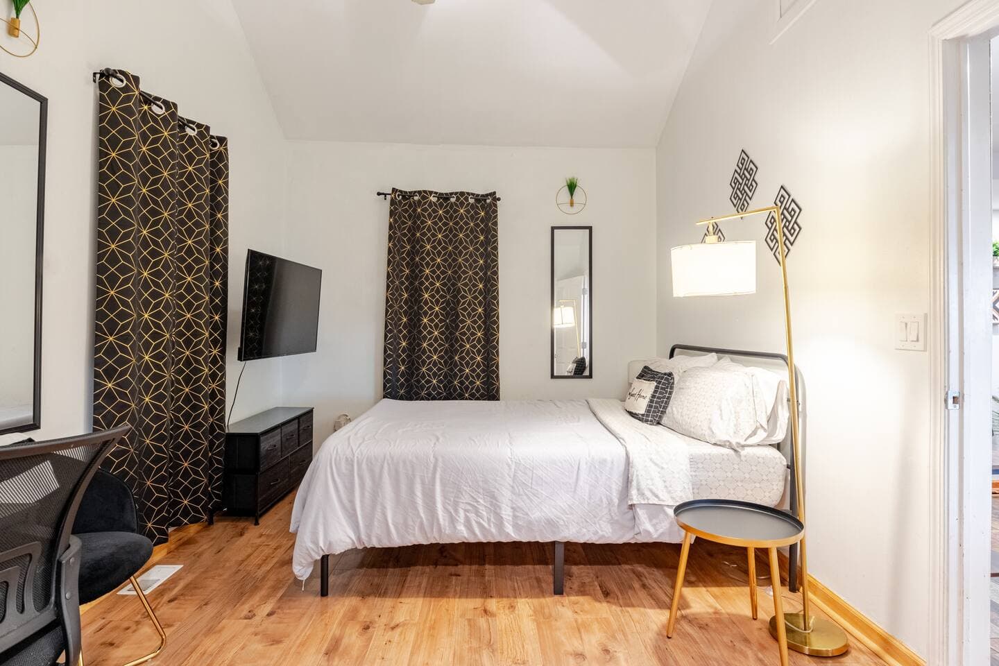 Bedroom 2 — queen with black-and-gold drapes and TV