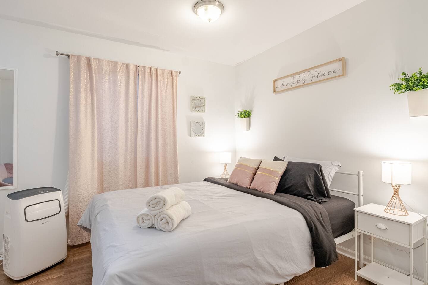 Bedroom 1 — pink room with nightstands and AC unit