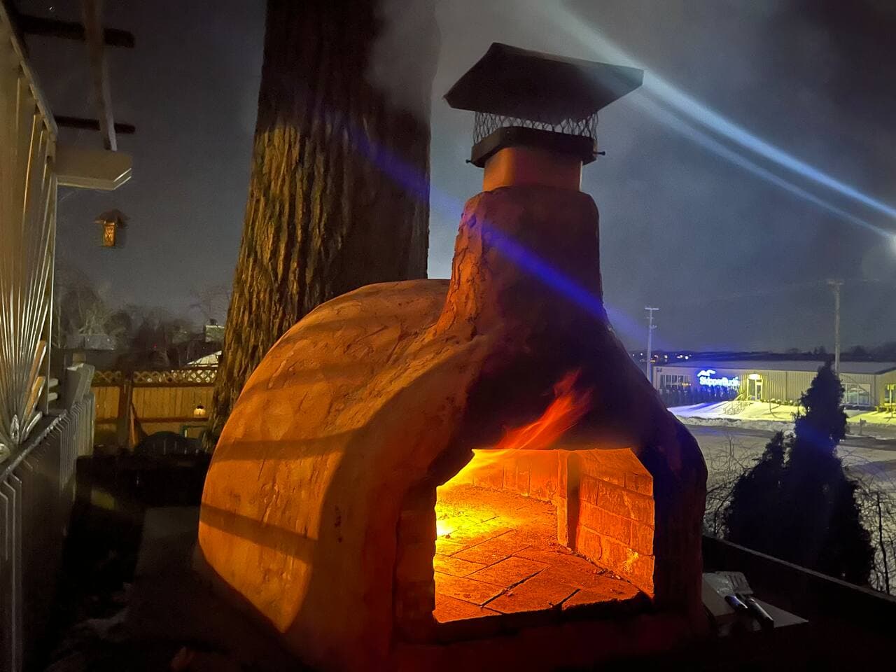 Wood-fired pizza oven fired up at night